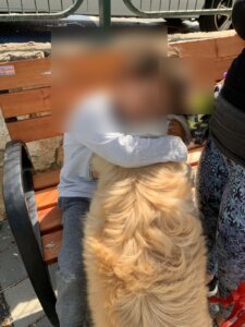ילד מחבק כלב במפגש כלבנות טיפולית